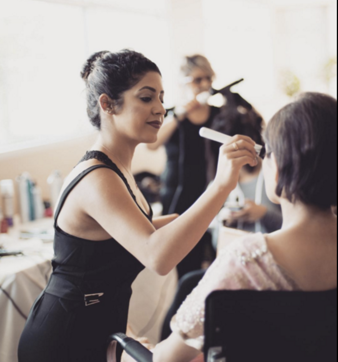 Rosheen Ahner applying makeup for a client as a licensed cosmetologist